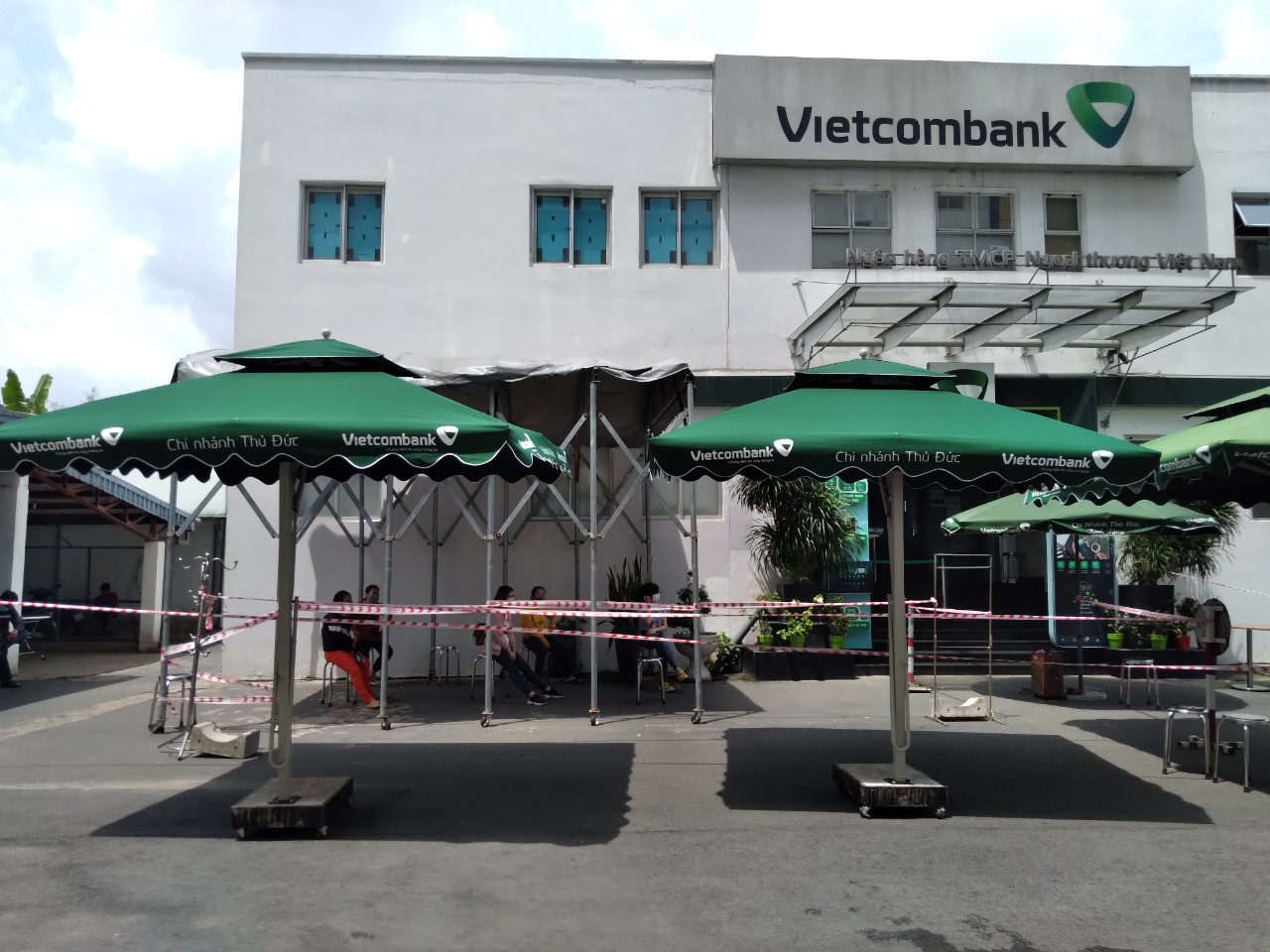 Cụm dù lệch tâm vuông hai tầng in logo Vietcombank bố trí tại sân trước điểm giao dịch.
