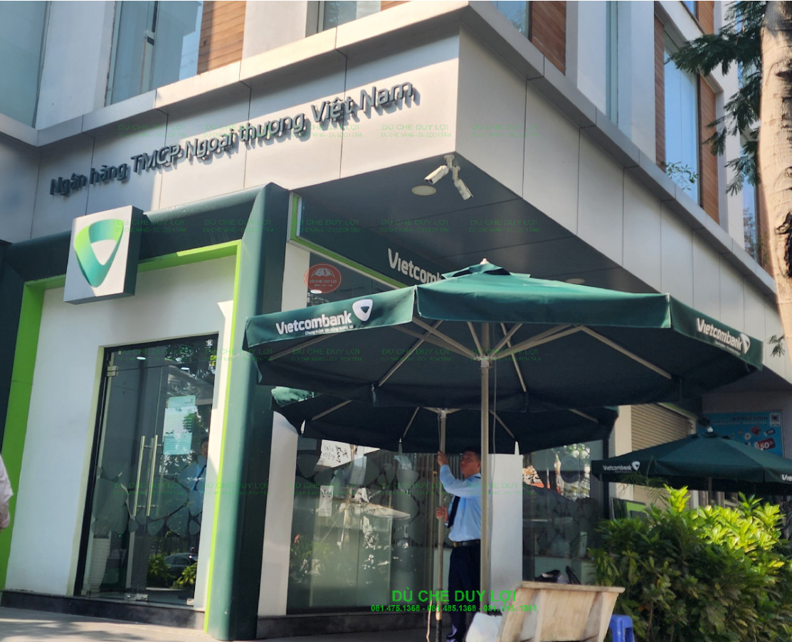 Dù tròn hai tầng in logo Vietcombank phối cùng nhận diện trên mặt tiền ngân hàng.