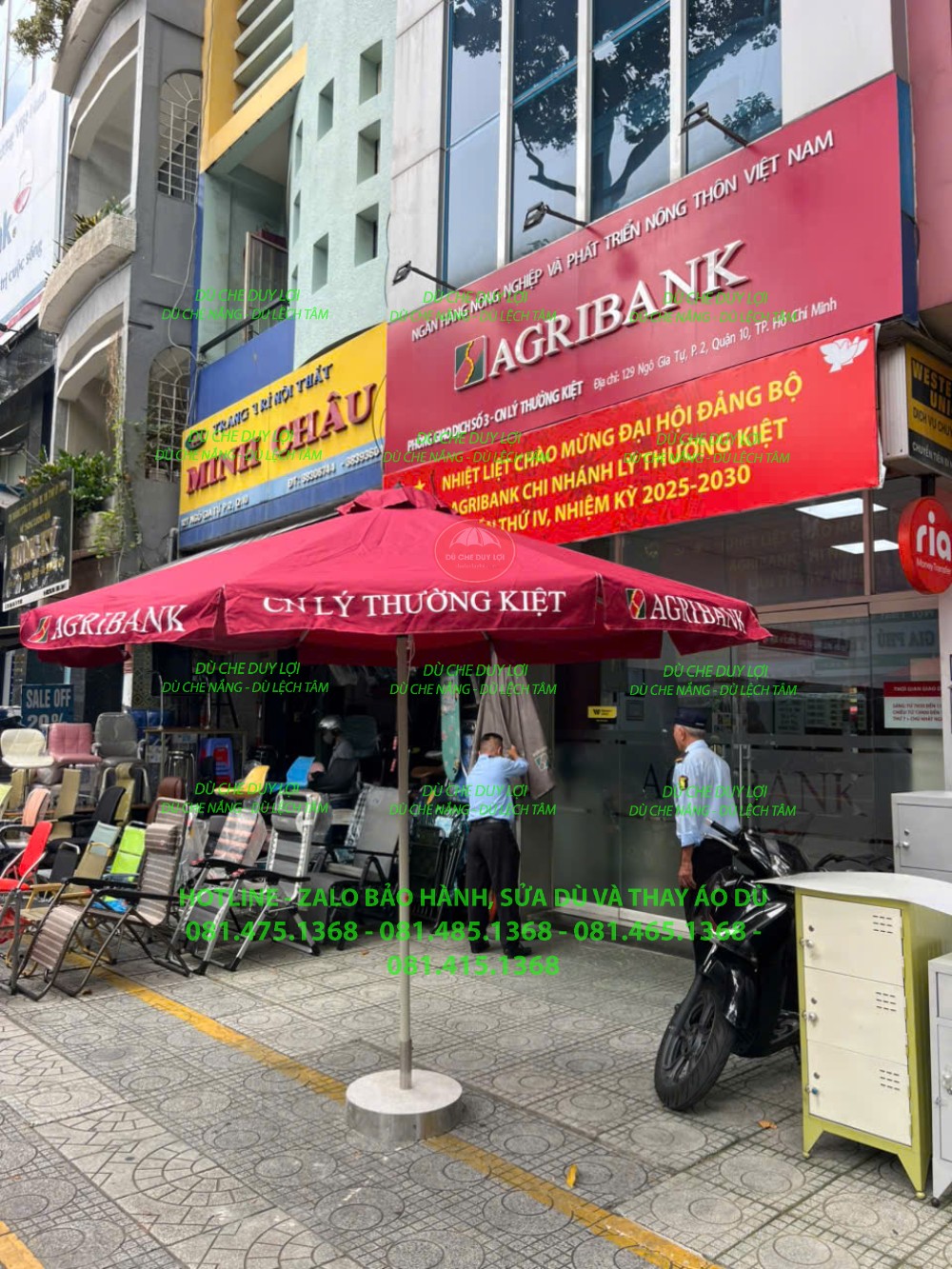 Dù tròn đúng tâm màu đỏ in nhận diện Agribank trước mặt tiền chi nhánh.