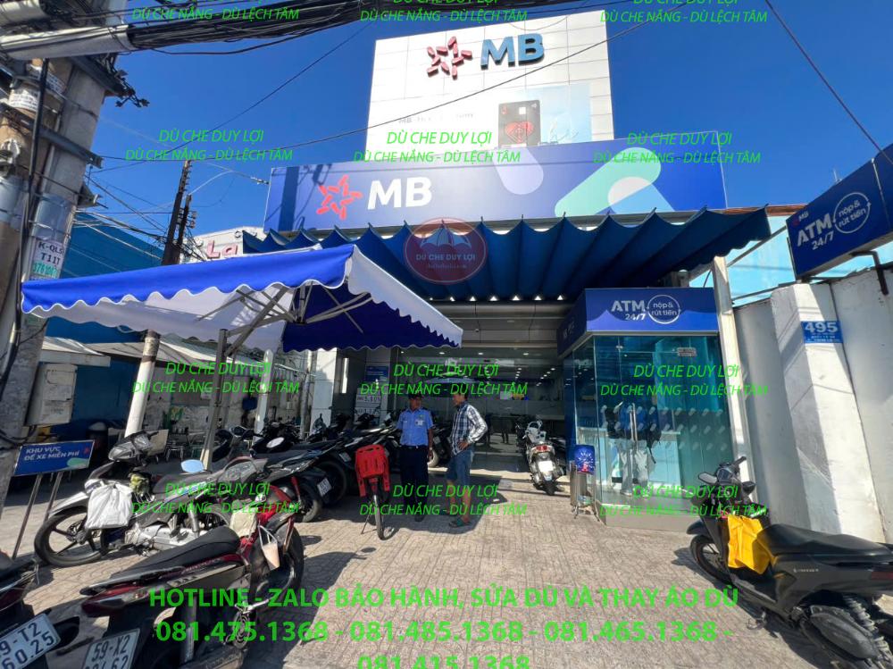 Dù che nắng trước ngân hàng MB gần biển ATM và cửa vào.