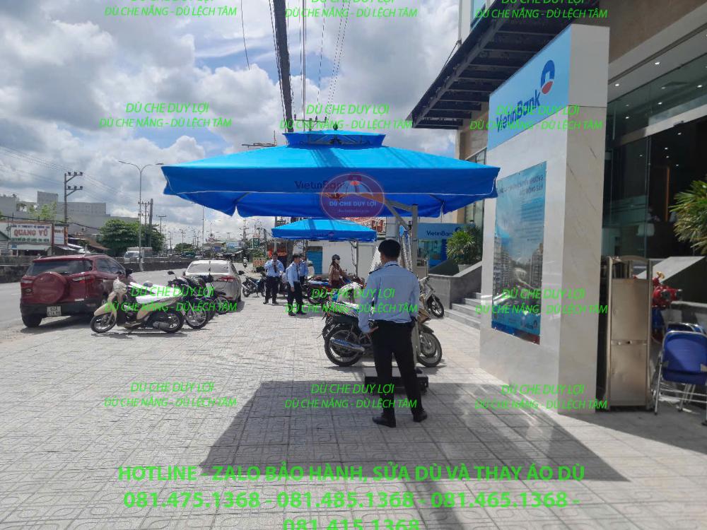 Dù màu xanh tại mặt tiền Vietbank gần khu vực khách và nhân viên tiếp cận.