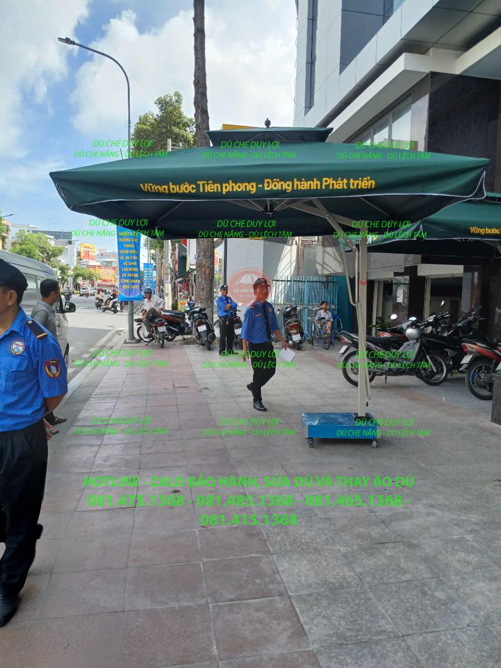 Góc nhìn dọc mặt tiền Vietcombank với dù che nắng gần bậc thềm và khu vực để xe.