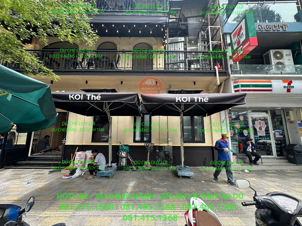 Hai bộ dù vuông màu đen mang nhận diện KOI Thé tại mặt tiền cửa hàng.