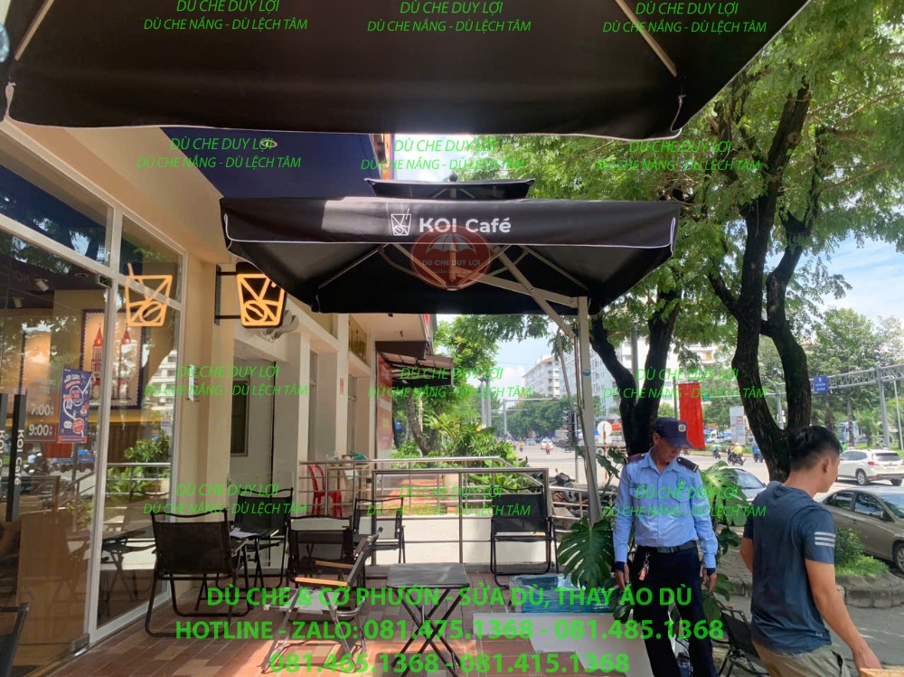 Dù đen KOI Café, bộ khung và khoảng bàn ghế nhìn từ bên dưới tán.