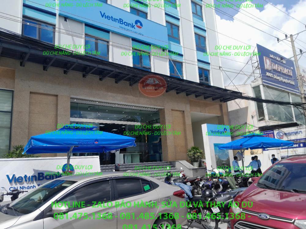 Các bộ dù lệch tâm vuông màu xanh trước công trình có biển hiệu VietinBank.